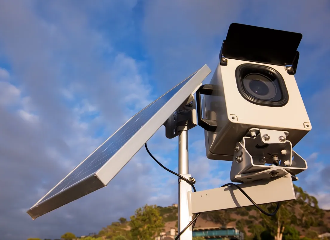A solar-powered long-term timelapse camera mounted on a pole, deployed on a construction site